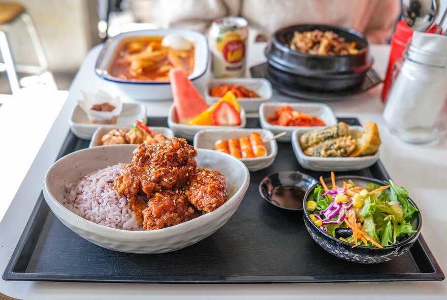 A table laden with Korean food in small plates. 