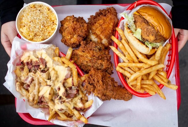 Burgers, fried chicken and sides on a red plastic tray