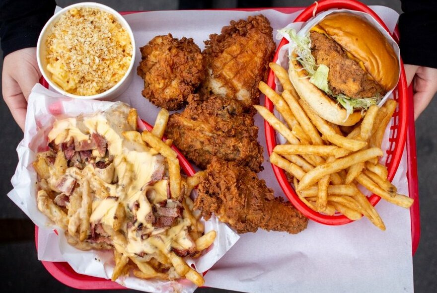  Burgers, fried chicken and sides on a red plastic tray