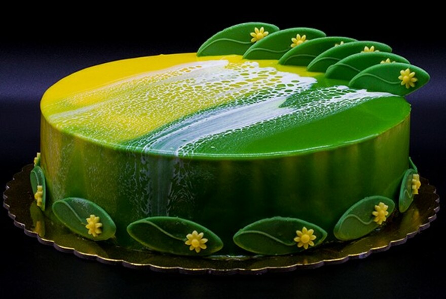 Green and yellow Aussie-themed cake with wattle leaf decoration.