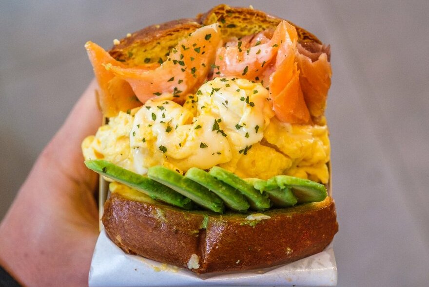 A sandwich with egg, salmon and avocado