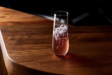 Pink cocktail with white garnish.