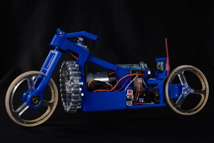 A blue handmade model of a motorbike made from individual components.