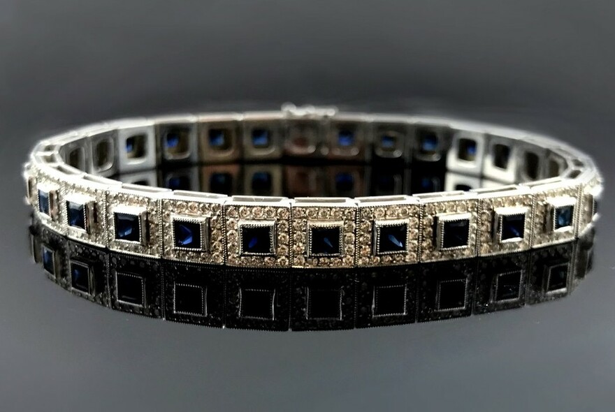 Platinum deco bracelet ringed with medallions with square blue stones.