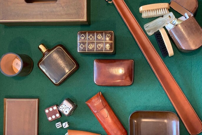 Assorted men's travel items including a leather flask, dice, brush and shoe horn.