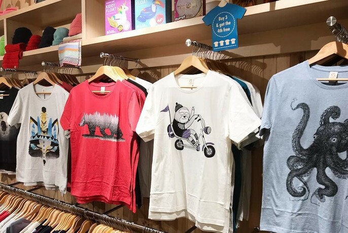 T-shirts with various motifs hanging on racks.