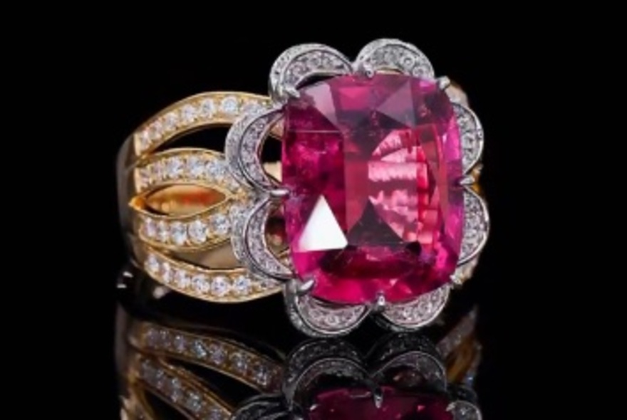Square cut ruby and diamond ring on a black glass display.