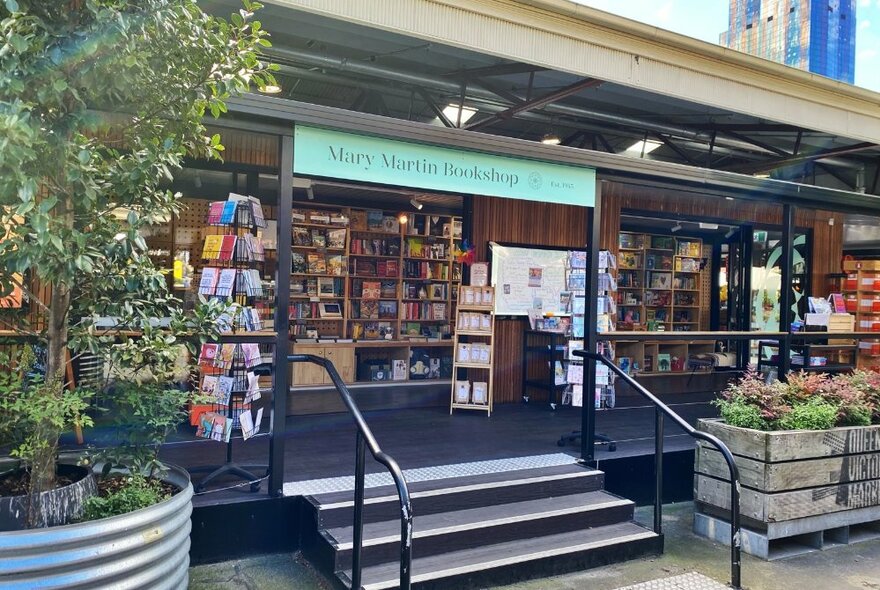 Entrance to Mary Martin Bookshop at String Bean Alley showing steps to a raised platform, potted plants out the front,,and a glimpse into the shop interior.