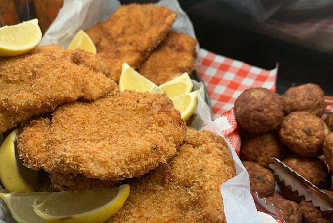 Schnitzels with lemon wedges and meatballs. 