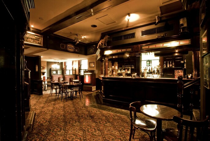 Inside a dimly-lit traditional English pub.