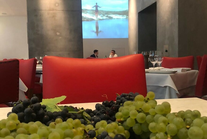 Black and green grapes and a red chair in a restaurant.