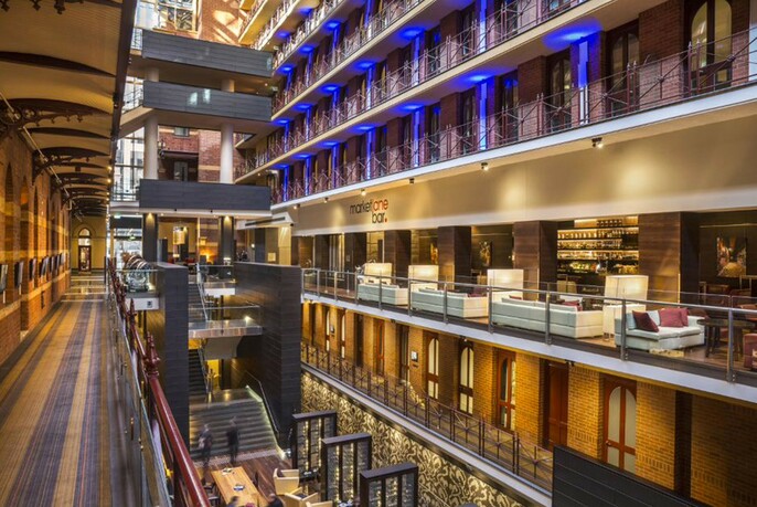 Interior of the glass atrium of the Rialto showing lounge seats and the bar one of the upper levels.
