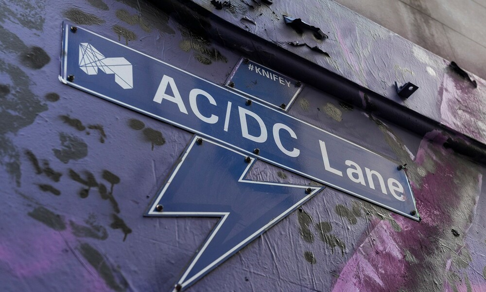 Lighting bolt sign for AC/DC Lane on the side of a wall. 