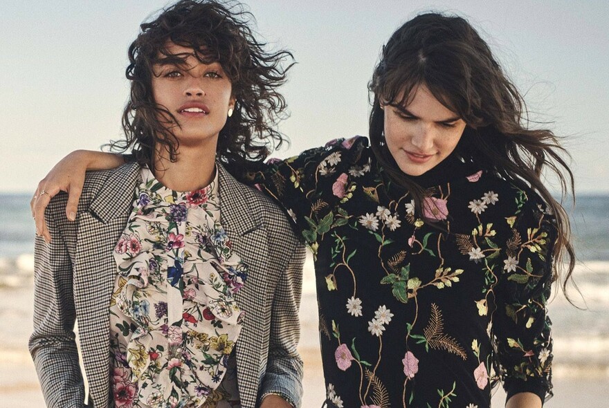 Two women wearing patterned tops.