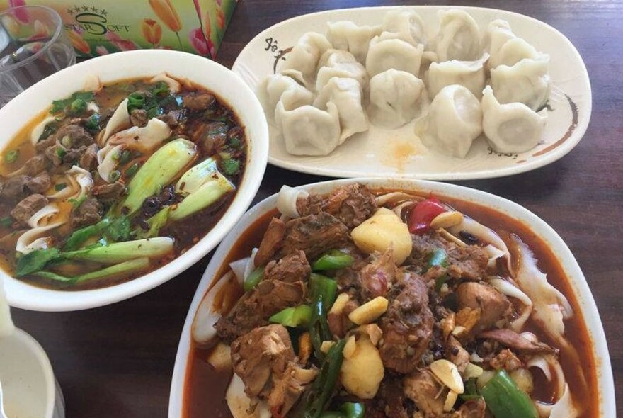 Array of dishes including dumplings and stews.