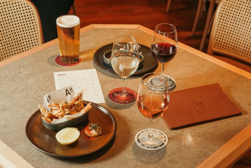 A selection of wines and beer on a bar table.