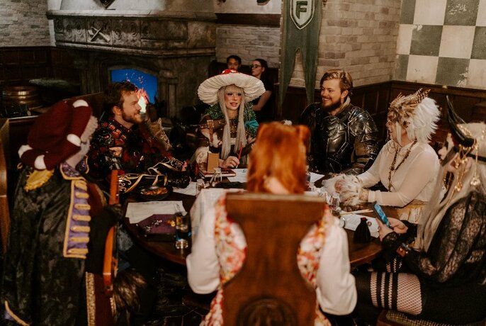 Dungeons and Dragons players seated around a table in costume.