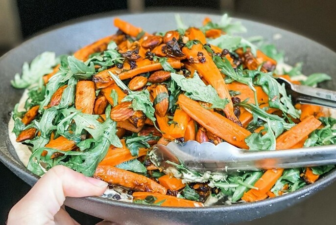 Bowl of rocket leaves and carrots. 