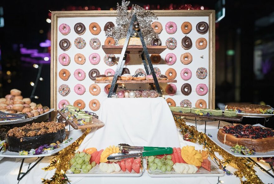 A dessert buffet table with a selection of sweet items and fruit platters.