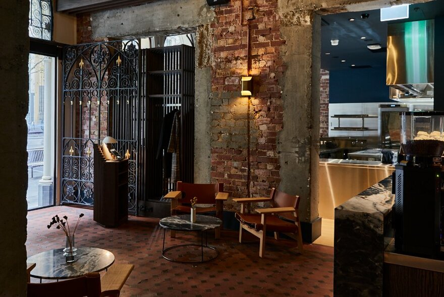 Restaurant interior with rough brick walls and metal gate.