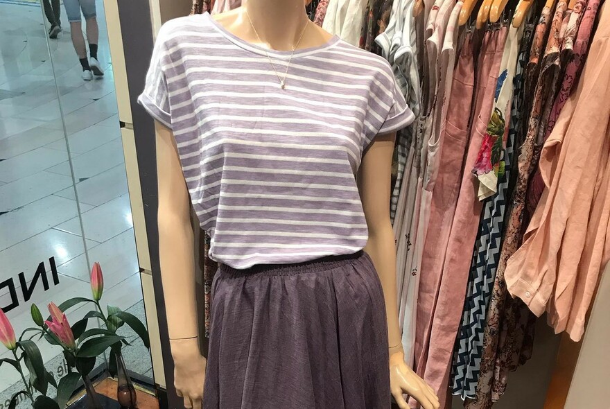 Stripy top and women's fashion on hangers inside Indigo store.