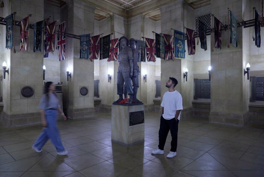 Two people experiencing an exhibition inside the Shrine of Remembrance.