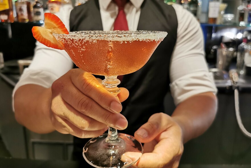 Waiter presenting a cocktail.