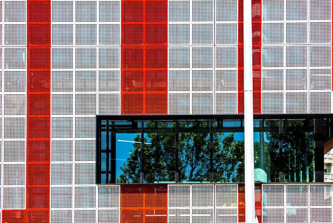 Close-up of city building showing large scale public artwork in contrasting red and white panels.