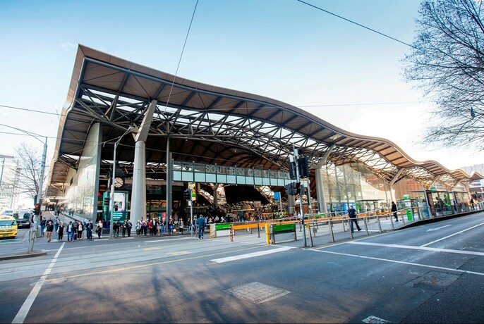 Long, wavy roof and large columns of Southern Cross Station, on the corner of Spencer and Collins streets. 