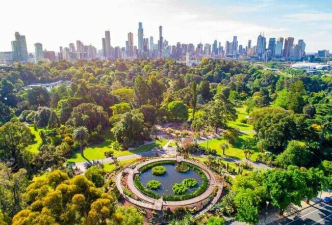 An aerial shot of a park with the Melbourne city skyline in the background.