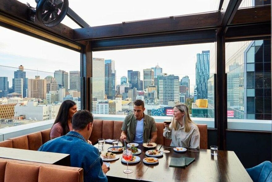 A group of four friends sit around the table at a bar