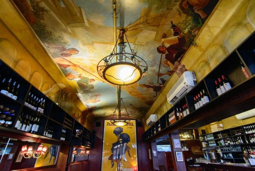 A French restaurant with a painted mural on the ceiling