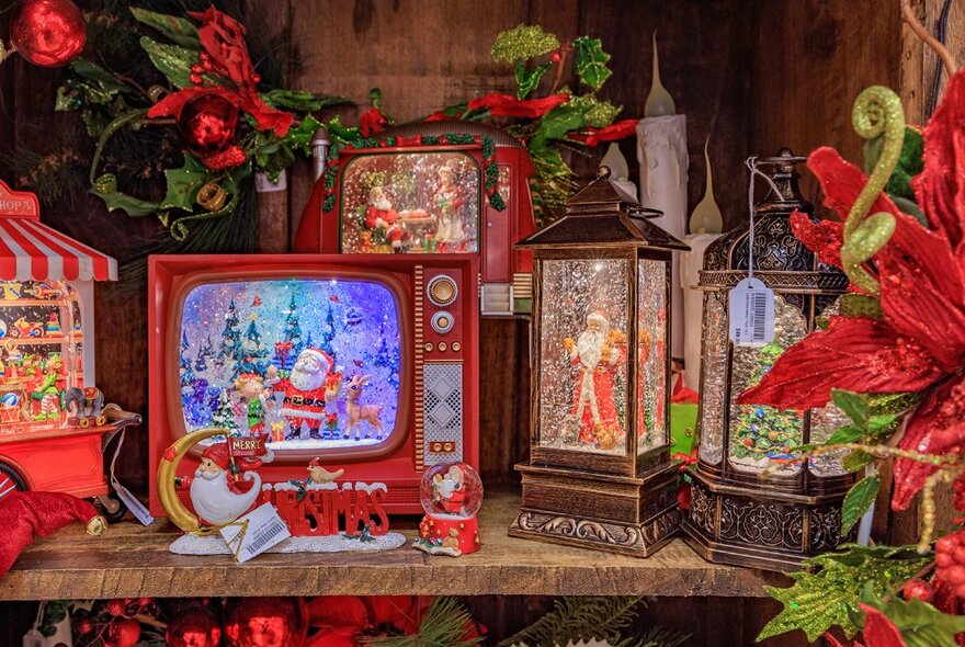 A shelf filled with Christmas-themed lanterns and decorations.
