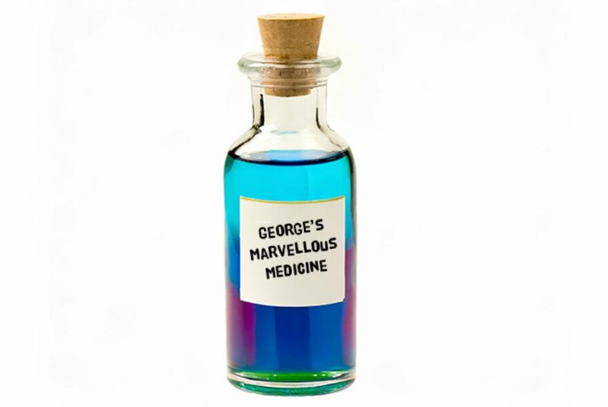 A glass bottle filled with multi-coloured liquid with a cork in its top, and a white label with the words GEORGE'S MARVELLOUS MEDECINE written on it. 