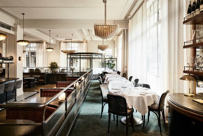 An elegant restaurant interior with floor to ceiling windows.