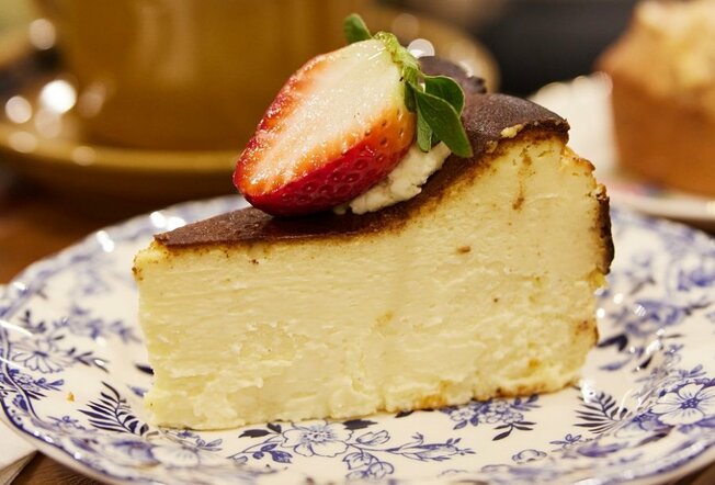 A slice of cheesecake on a plate with a strawberry on top