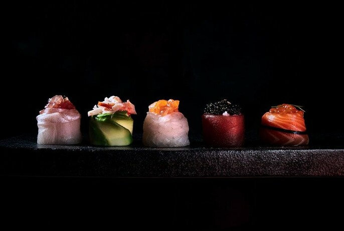 Exquisite sushi on a black plate.