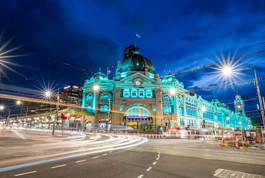 Flinders Street Station illuminated blue at night.