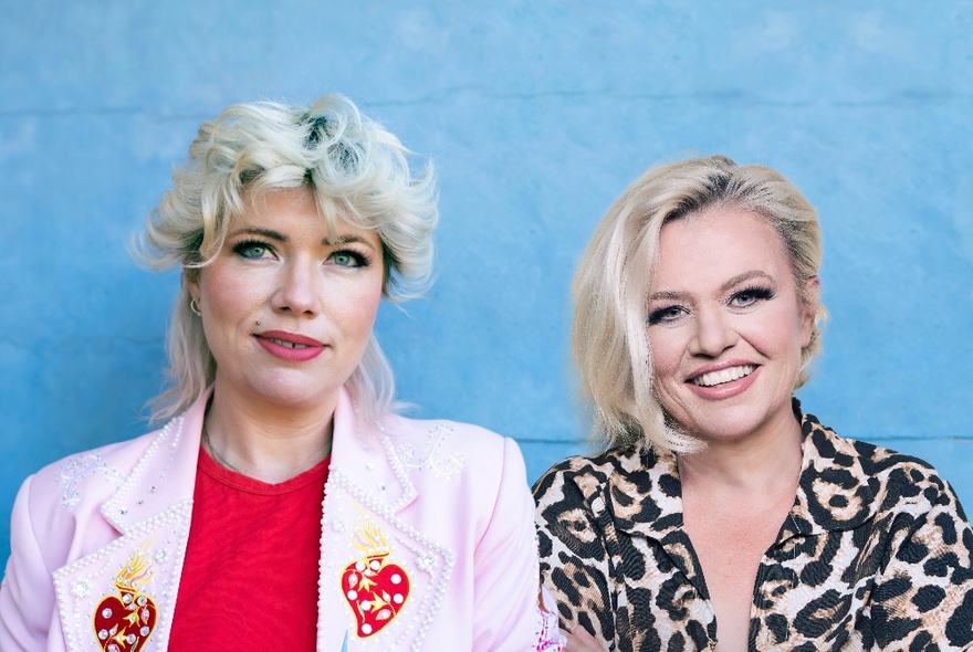 Writer Clementine Ford and musician Libby O’Donovan, both with blonde hair, one wearing a pink jacket with hearts, the other wearing a leopard-print top.