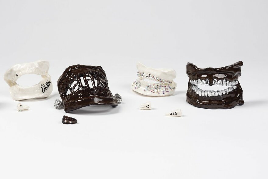 Art pieces showing sets of teeth in black and white, with decorations. 
