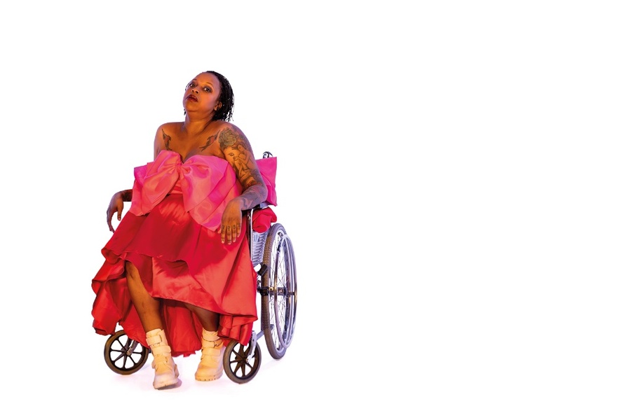 An illustration of a woman in a pink party dress seated in a wheelchair looking up. 