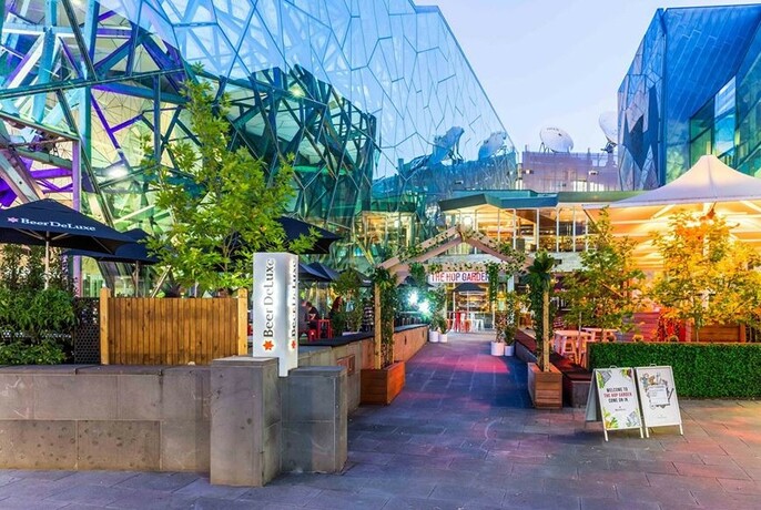 Fed Square restaurant exterior with tented outdoor seating, signage and umbrellas.