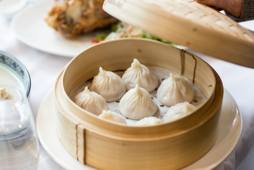 A bamboo basket with steamed dumplings inside.