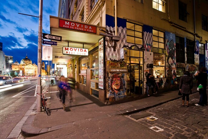 MoVida exterior on Flinders Street corner with logo lighting and graffiti.