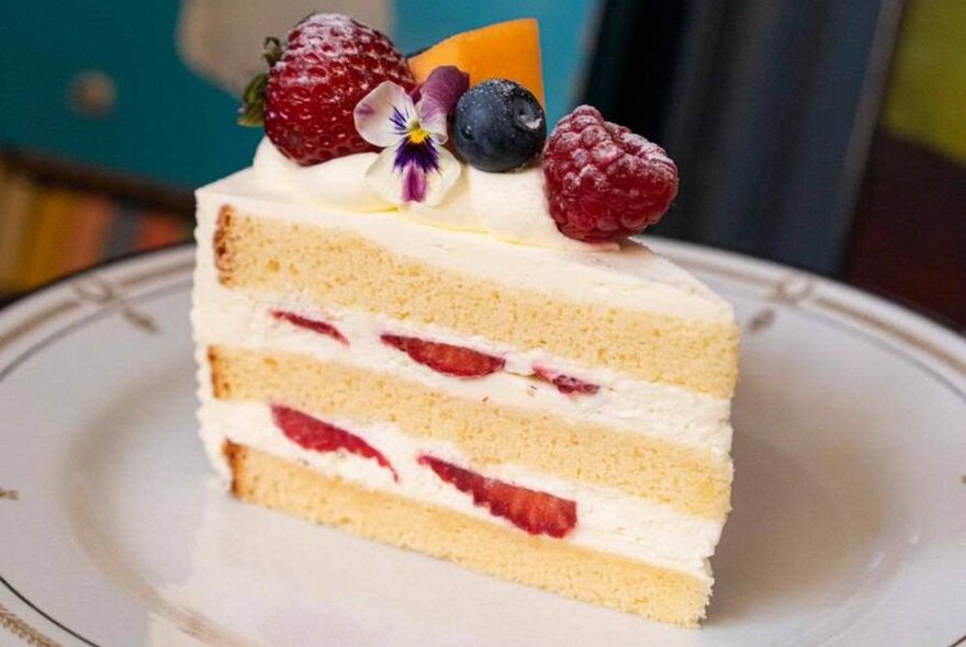 A slice of layered strawberry and cream cake.