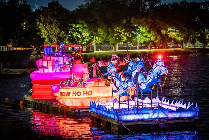 A Christmas art installation of Santa and dolphins floating on the Yarra River, at night.