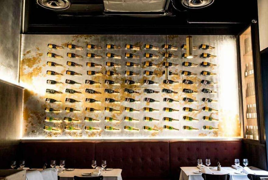 A wall installation of champagne bottles in a restaurant