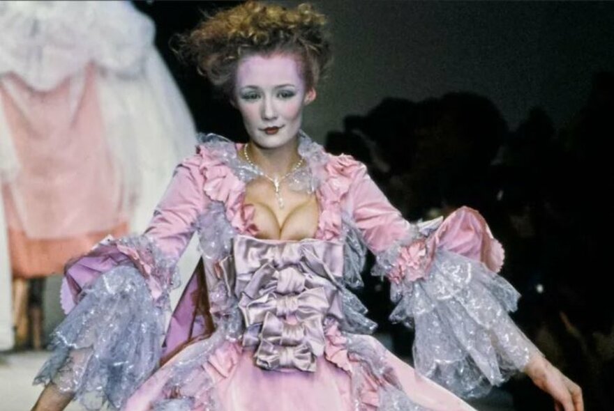 Model wearing a Vivienne Westwood design inspired by an18th-century gown, featuring pink and lilac ruffles, lace and ribbons.