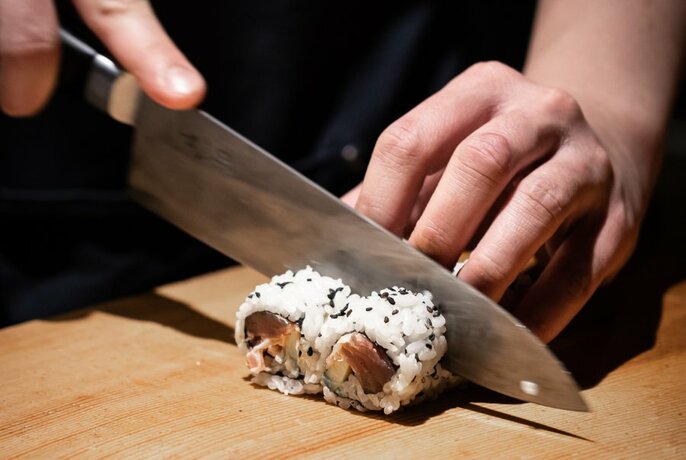 Person cutting sushi.