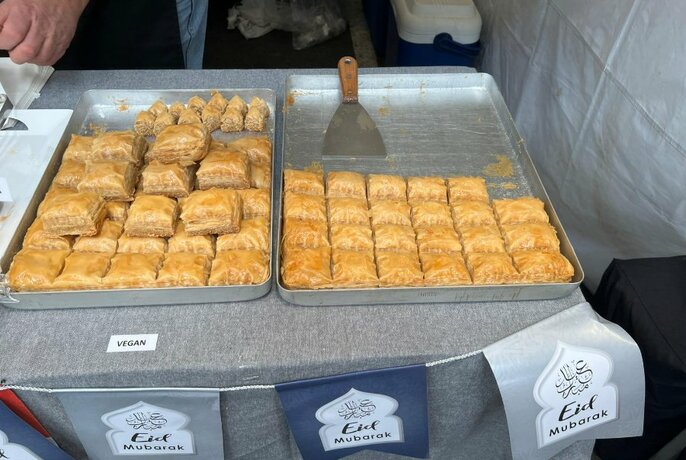 Two large trays of sweet pastries at a food stall.